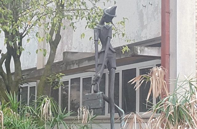Il Pinocchio all'ingresso della scuola che verrà abbattuta a fine novembre