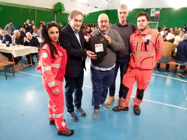 Alberto Caporalini e Luigino Bronzini con i volontari della Croce Gialla durante la consegna del defibrillatore