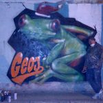 Michele Droghini, in arte Geos, a fianco di uno dei suoi graffiti