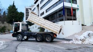 Il camion scarica la neve davanti alla Regione