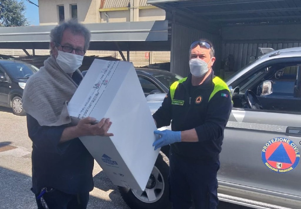 il coordinatore del gruppo comunale di Protezione civile Thomas Galassi riceve uno scatolone di mascherine in dono da Claudio Scataglini