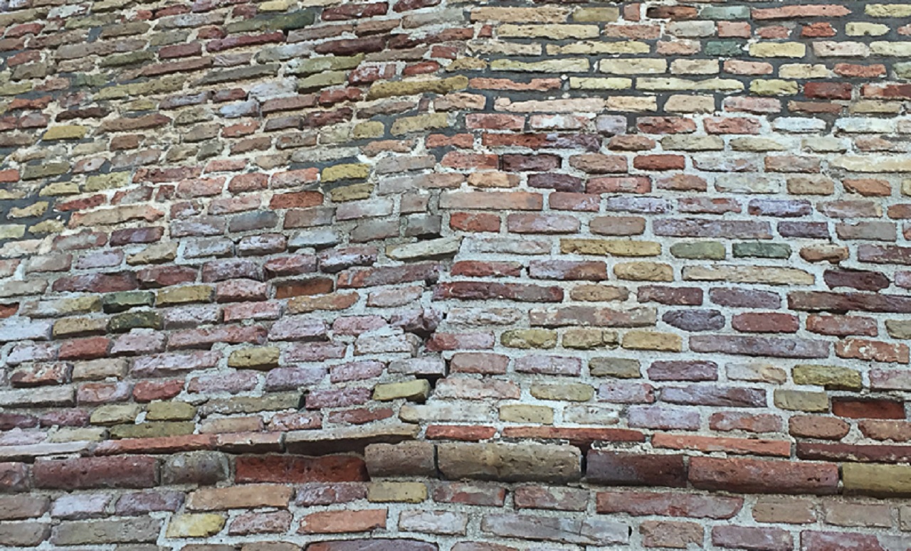 Lo stato di un tratto delle storiche mura di Corinaldo: segnalato la fessurazione tra alcuni mattoni