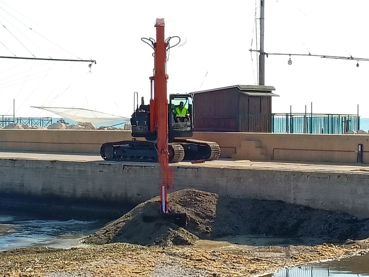 I lavori per aprire un varco nella diga naturale di ghiaia e detriti formatasi alla foce del fiume Misa a Senigallia